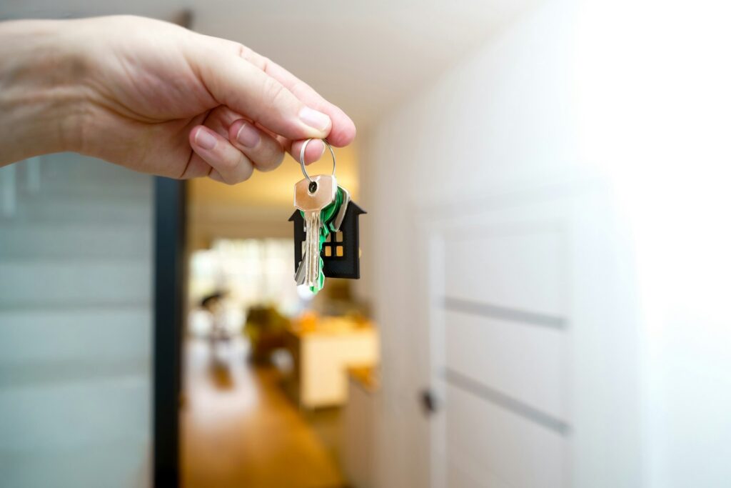Hand holding house keys during a rental handover